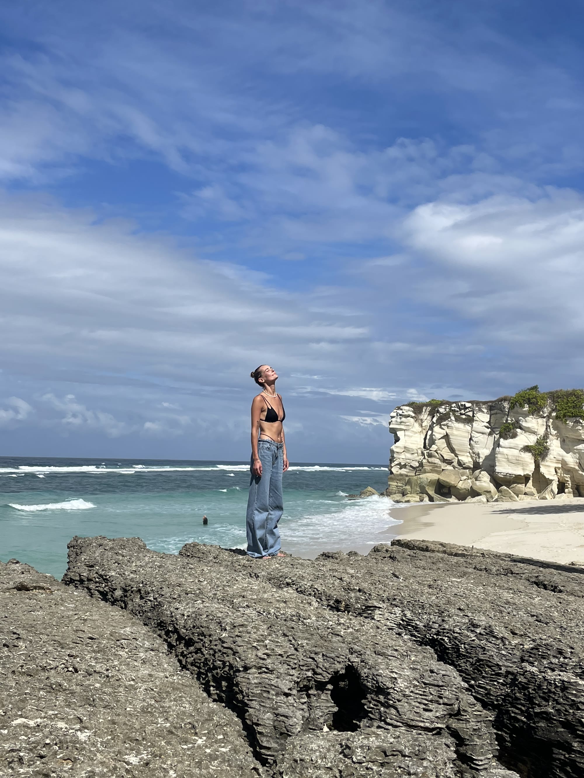 Rock outcrop overlooking a turquoise bay in Sumba, Indonesia