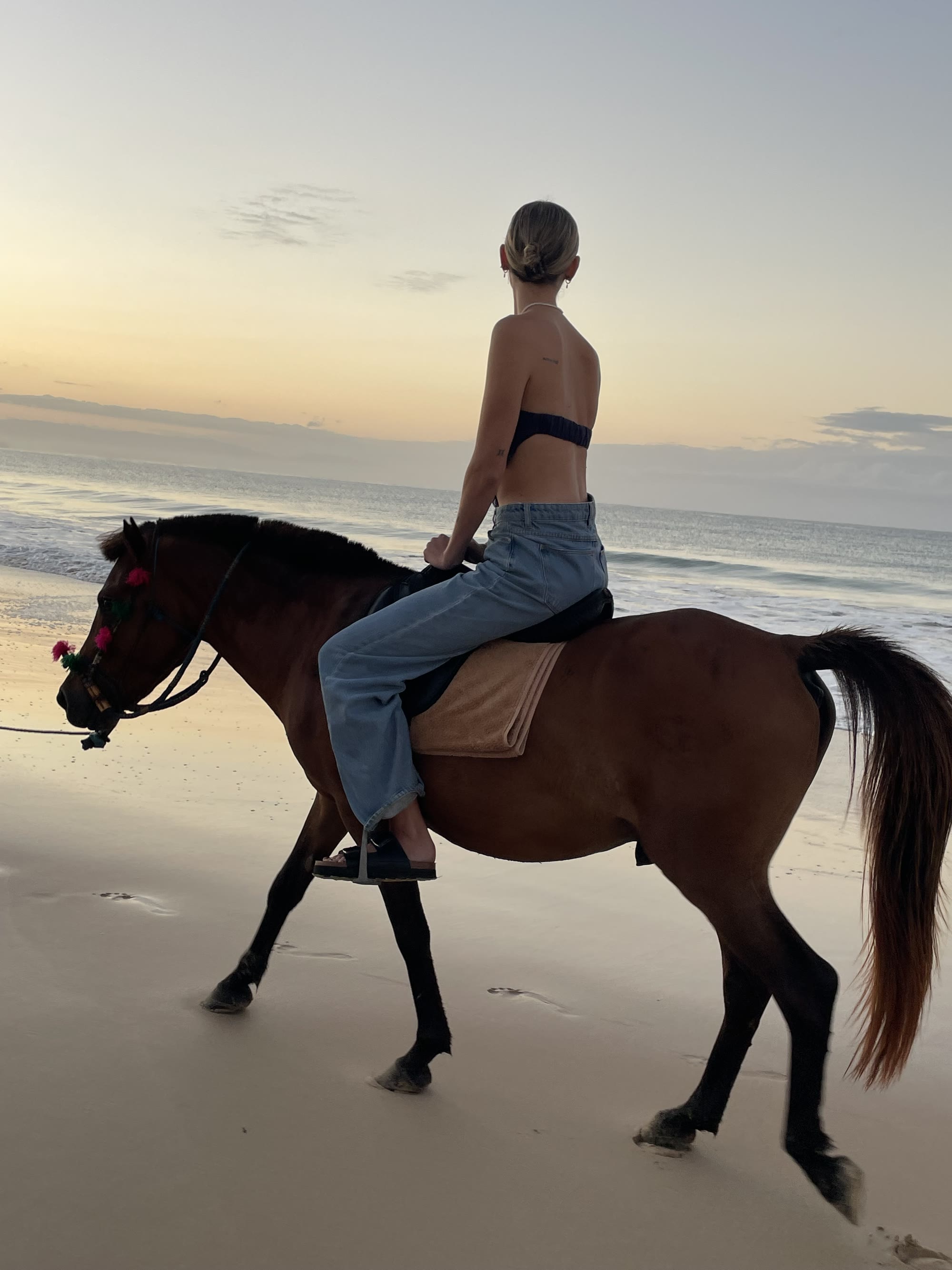 Riding a horse along the beach at sunrise at Rua Beach, Sumba